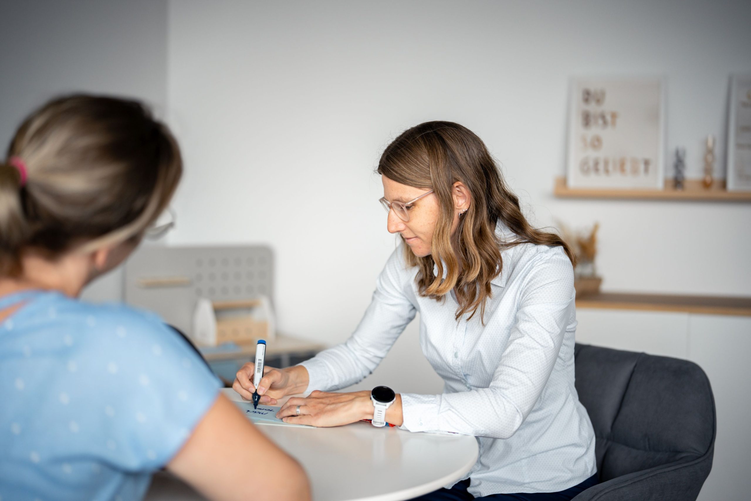 Daniela Koster mit Klientin im Coaching, beide sitzen an einem Tisch