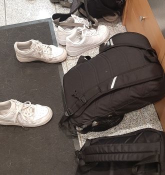 Rucksäcke und Schuhe liegen in einem Flur verteilt auf dem Boden