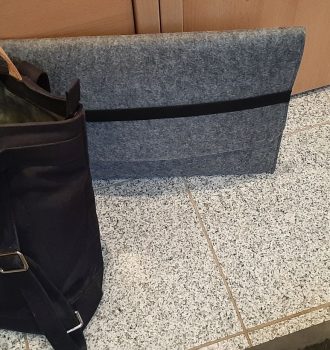 eine Tasche und Laptoptasche stehen auf dem Boden vor einem Schrank